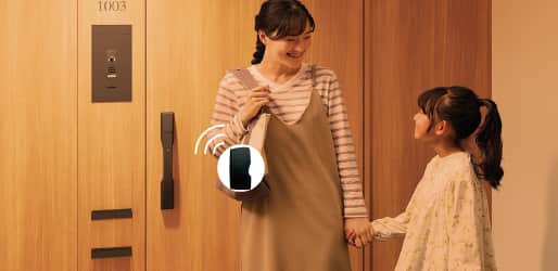 母親が子どもと手を繋いだ状態で、鞄のTebraキーが反応して解錠する様子