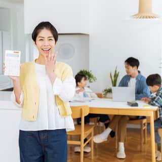 電卓を手に喜ぶ女性